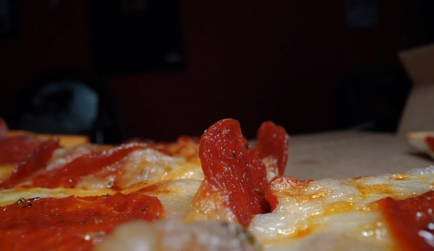 Melted cheese and vibrant pepperoni slices on a pizza slice